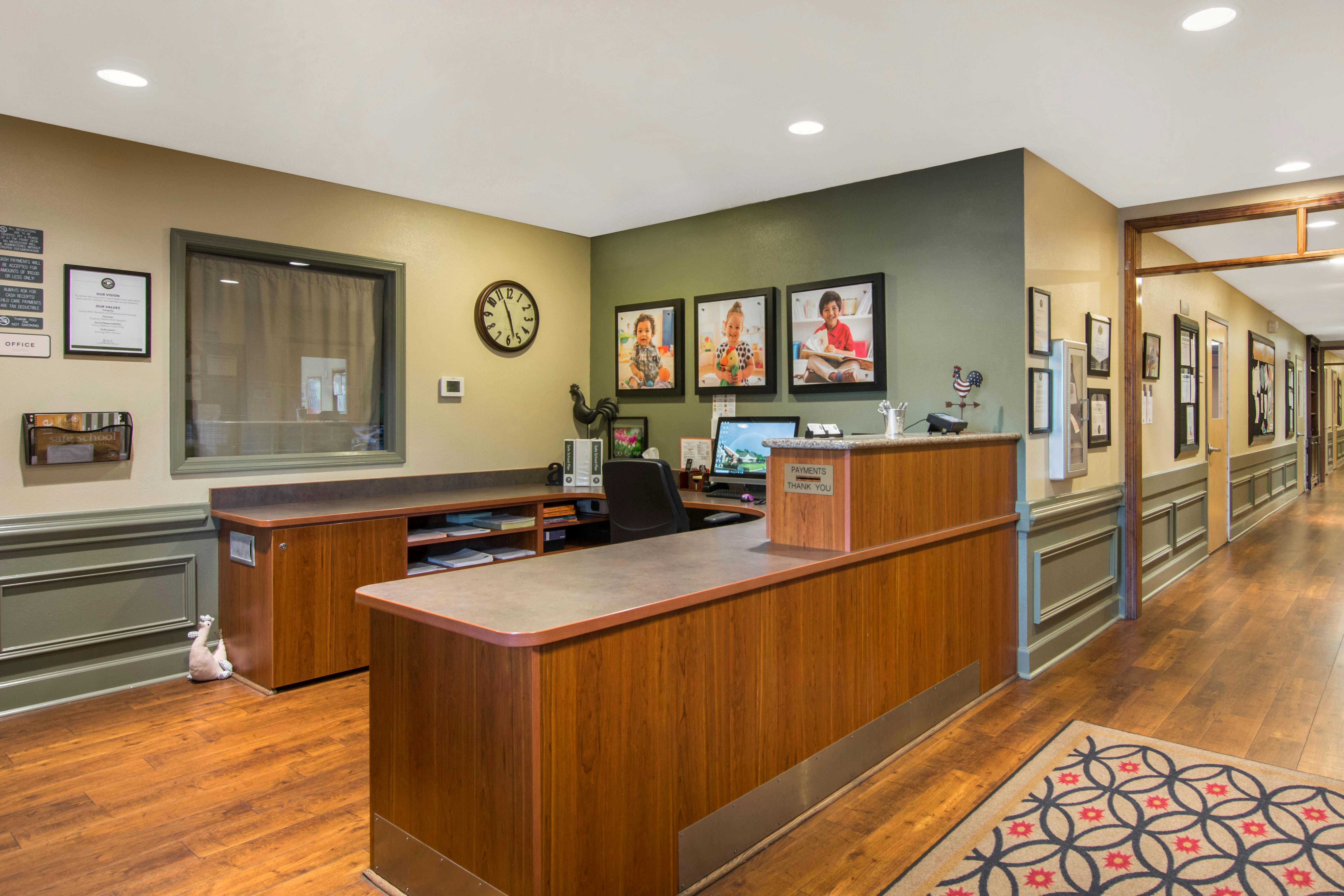 Reception desk with three framed photos of children above it