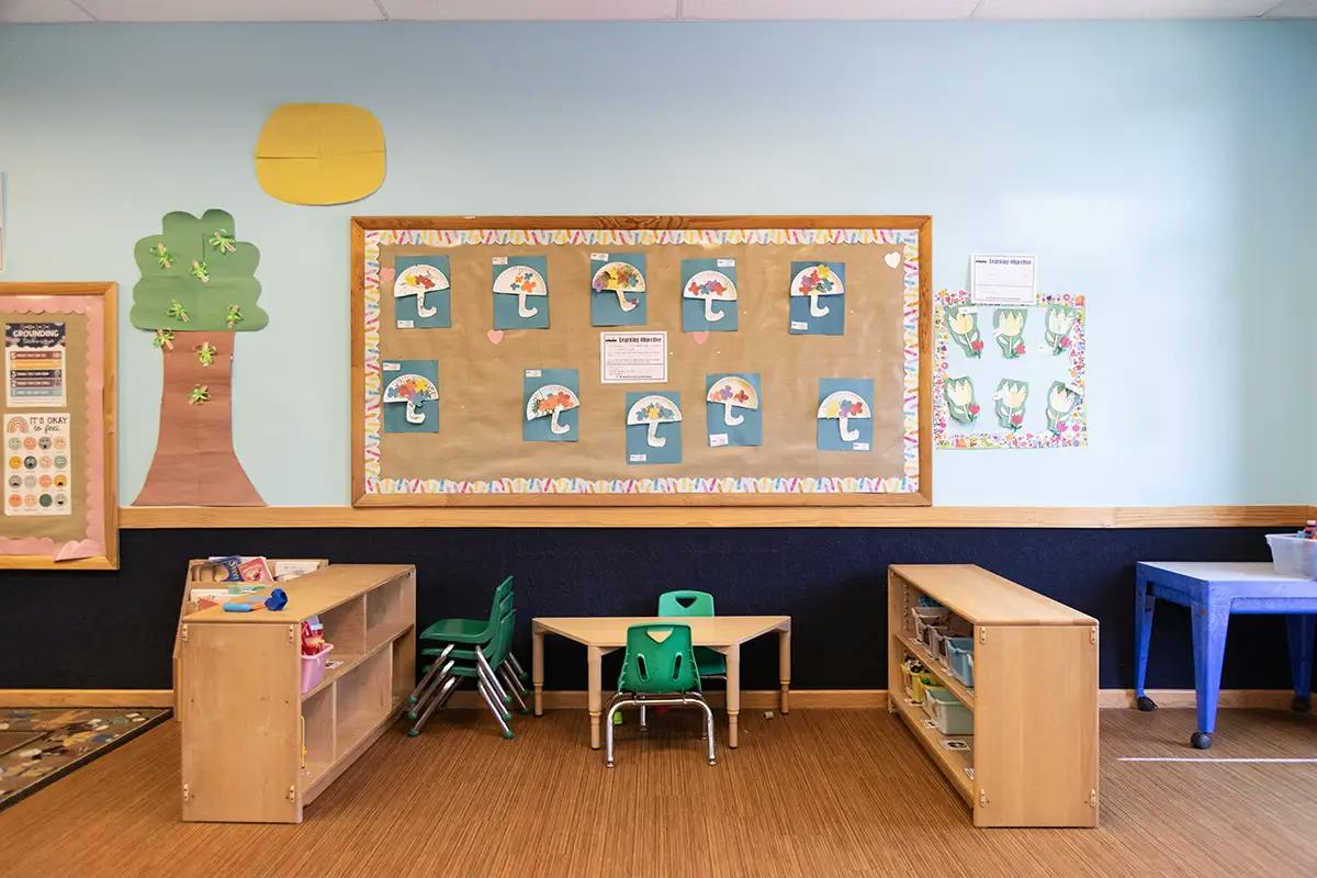 Classroom wall with a bulletin board displaying children's paper umbrella crafts