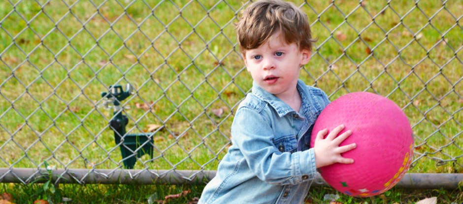 Child holding a pink ball