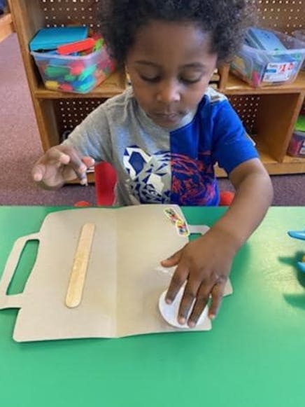 Child working on a craft project at a table