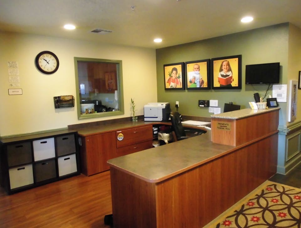 Reception desk with a window, clock, and framed pictures on the wall