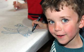 Child drawing on paper with a marker