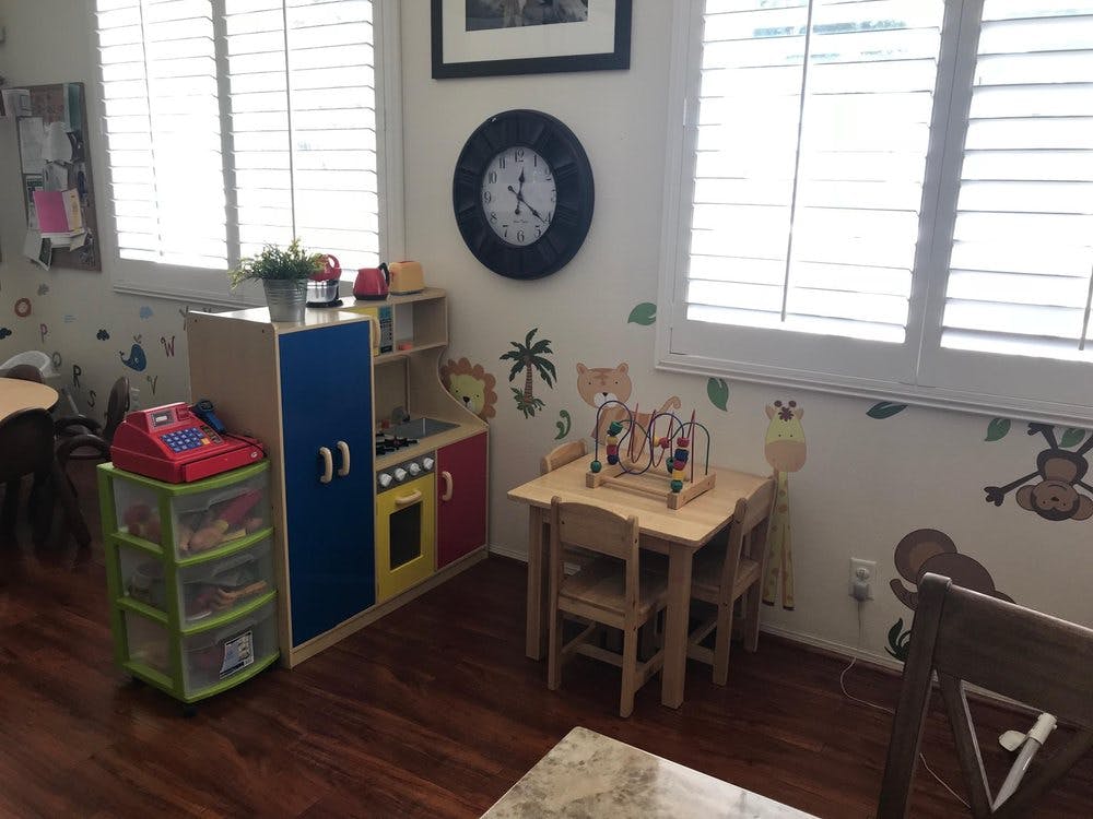 Playroom with small table and chairs, toy kitchen, and storage unit