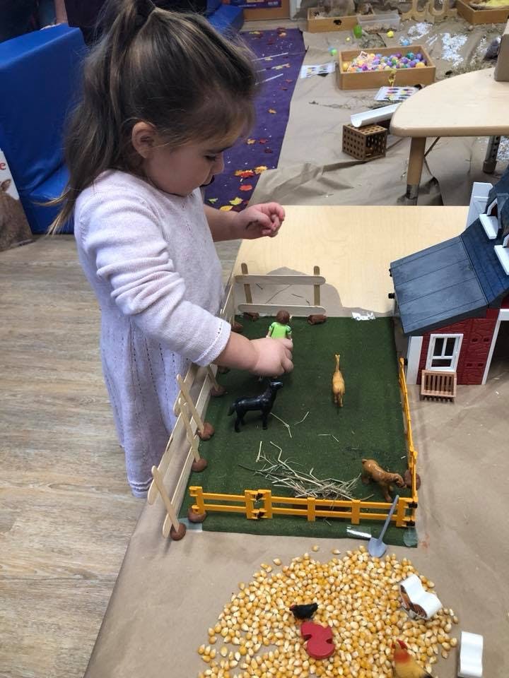 Child playing with a toy farm set
