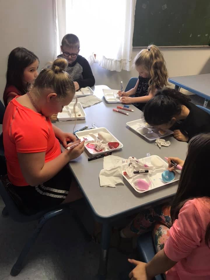 Children at a table working on art projects