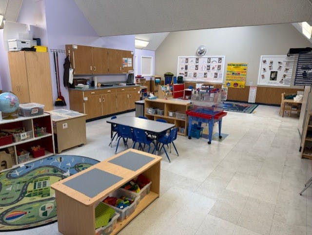 Classroom with tables, chairs, cabinets, and play areas