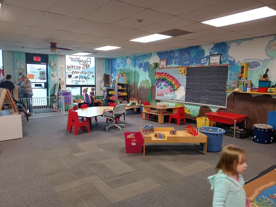 Child in a classroom with tables and chairs