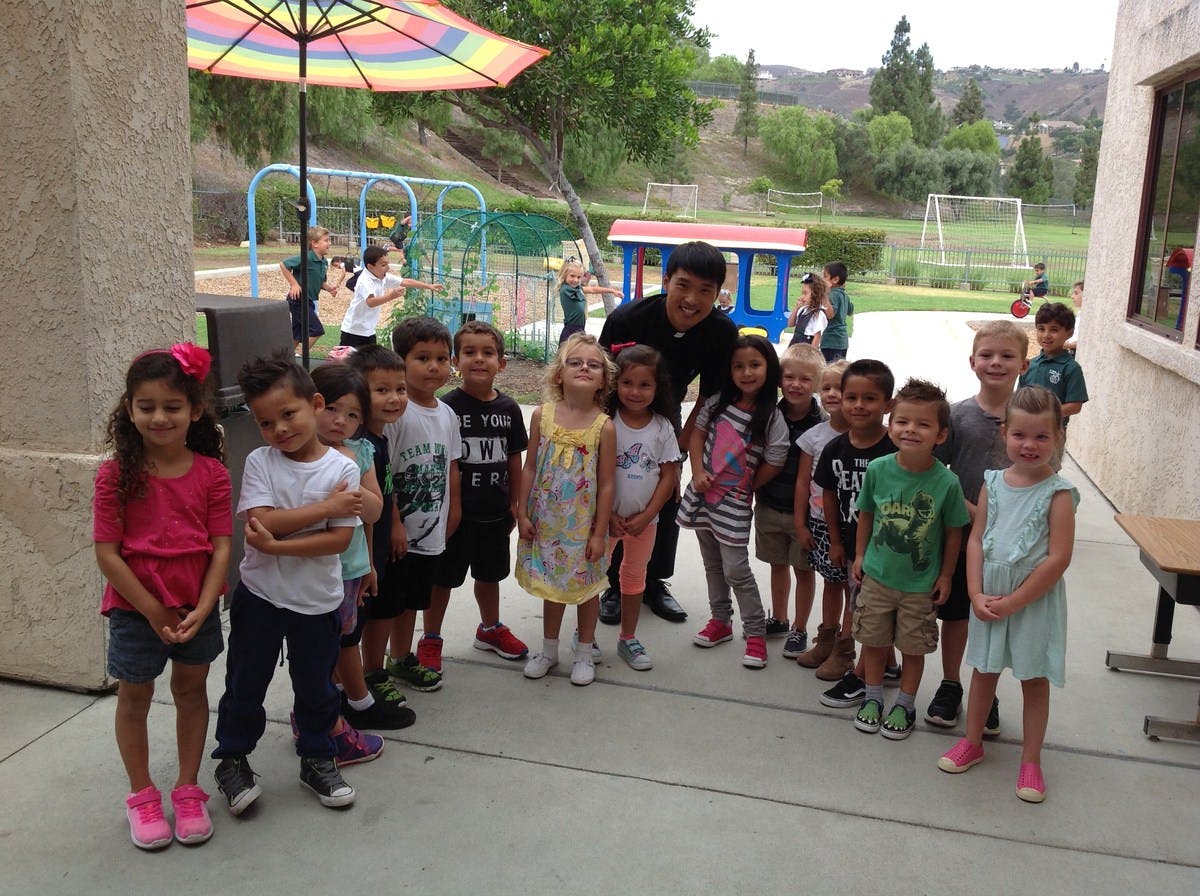 Adult and group of children posing outdoors