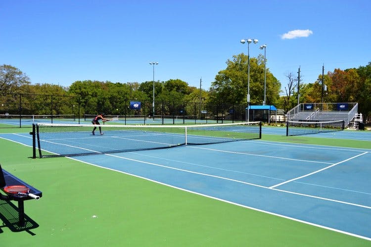 Person playing tennis on a blue and green court