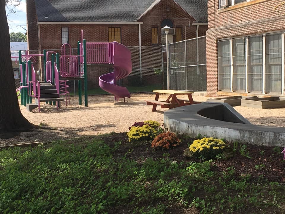 Playground with pink and purple play structure and picnic table