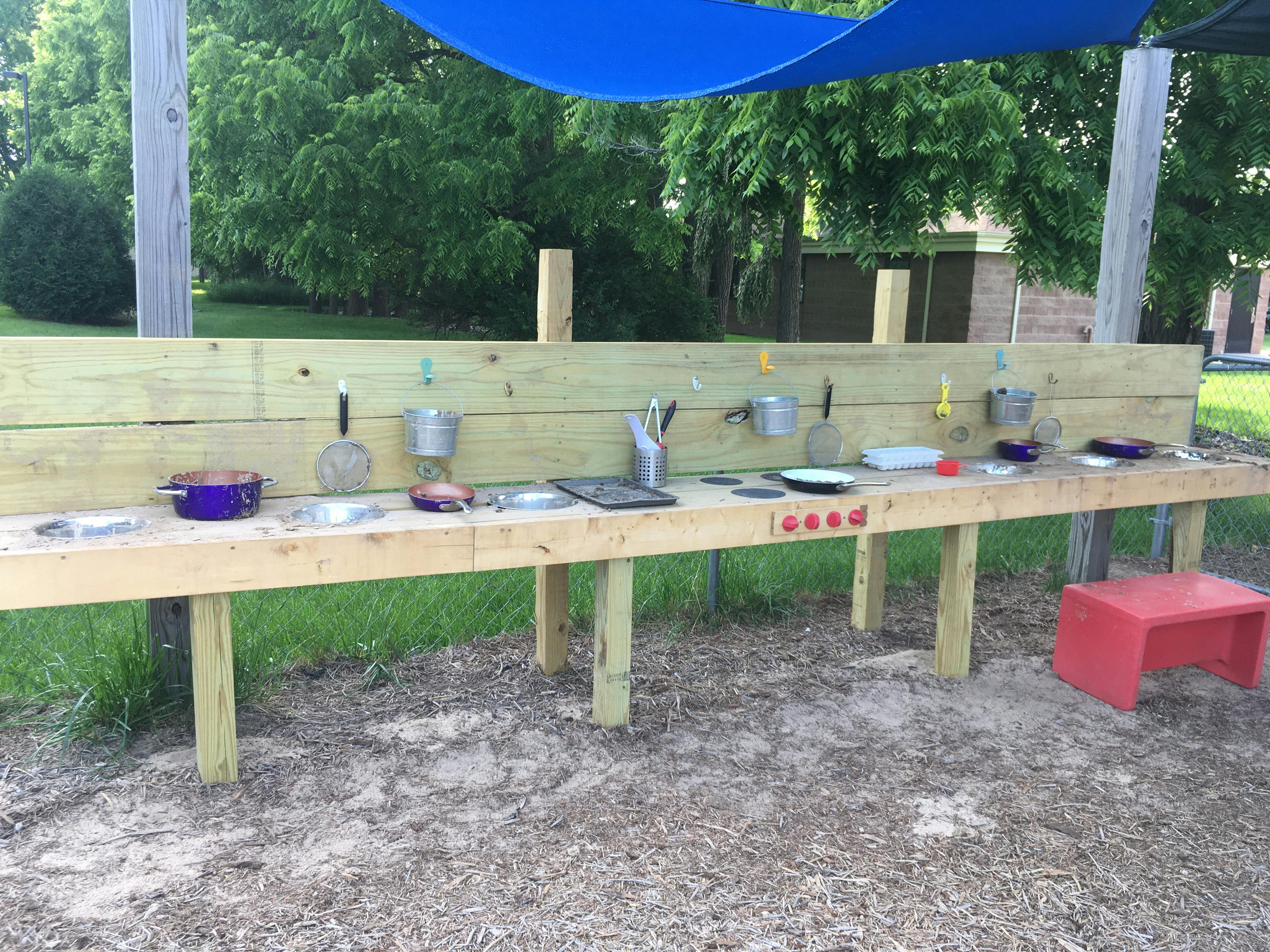 Wooden outdoor play kitchen with pots and pans