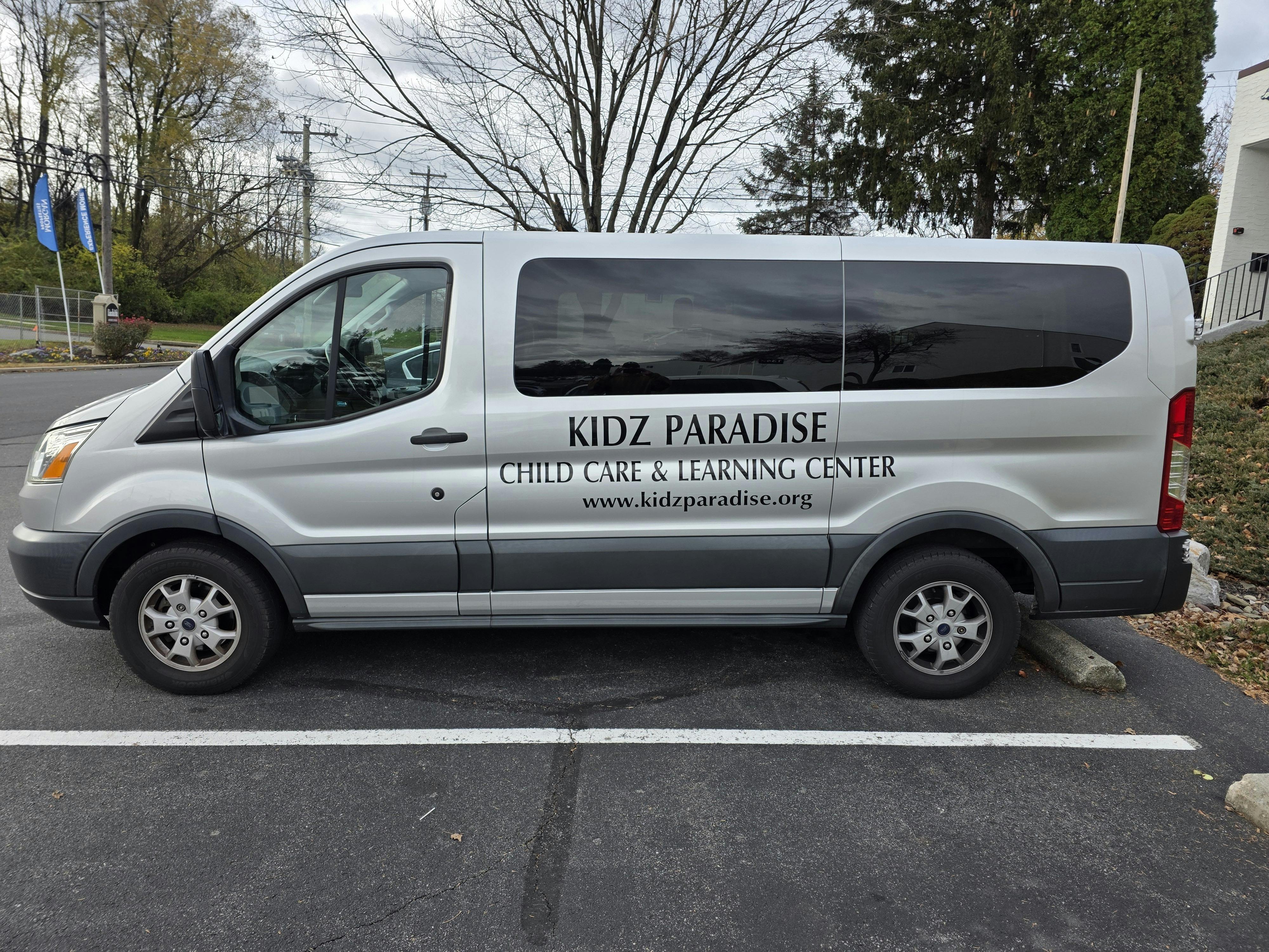 Silver van with "Kidz Paradise Child Care & Learning Center" on the side