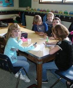 Children and teens sitting at a table