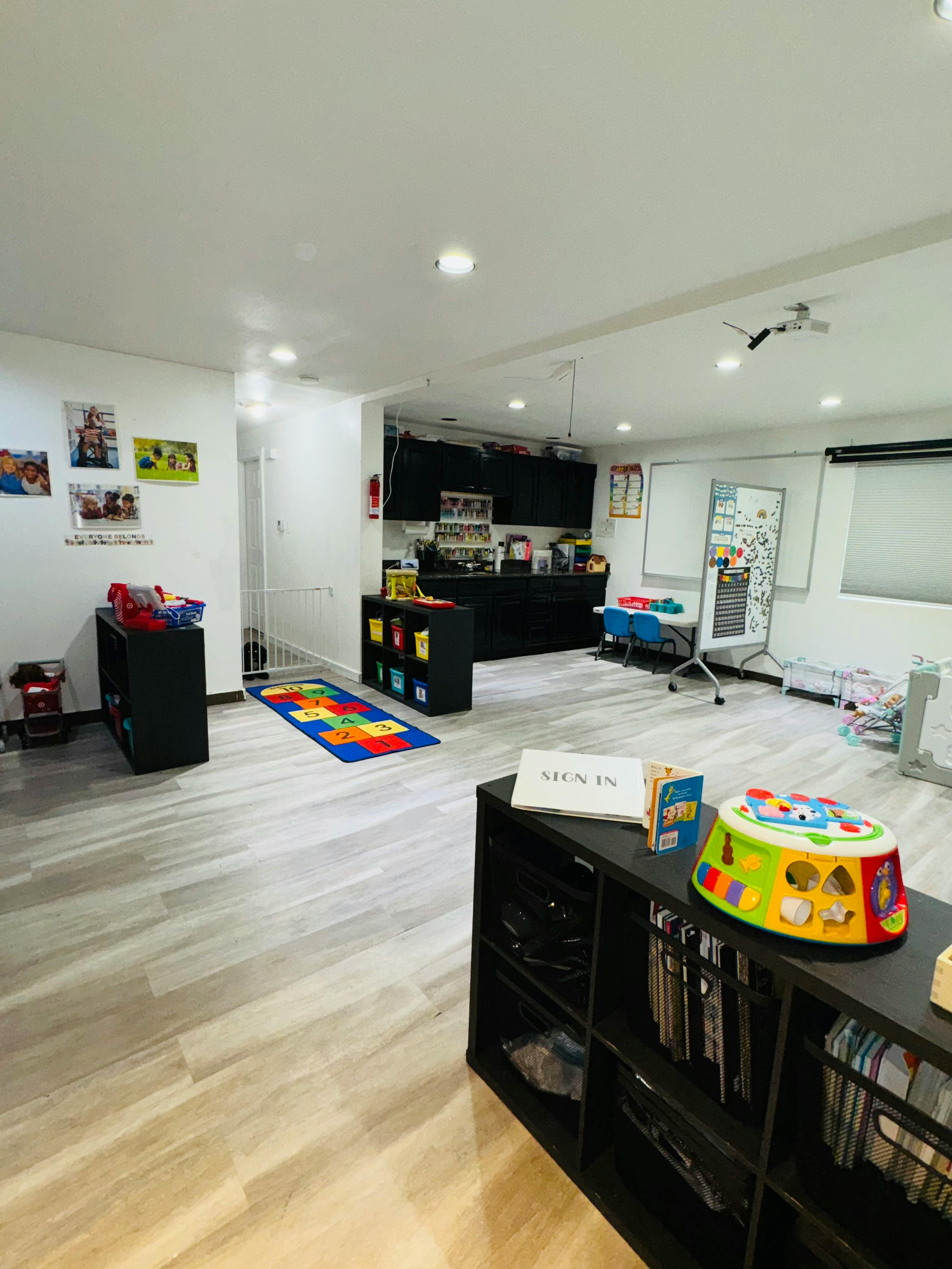 Playroom with toys, shelves, and a colorful rug
