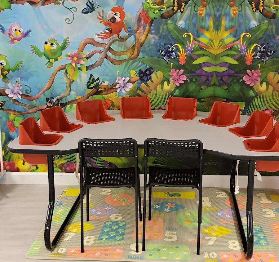 Classroom table with red booster seats and black chairs