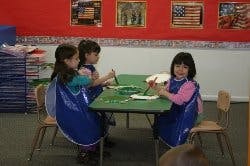 Three children painting at a table