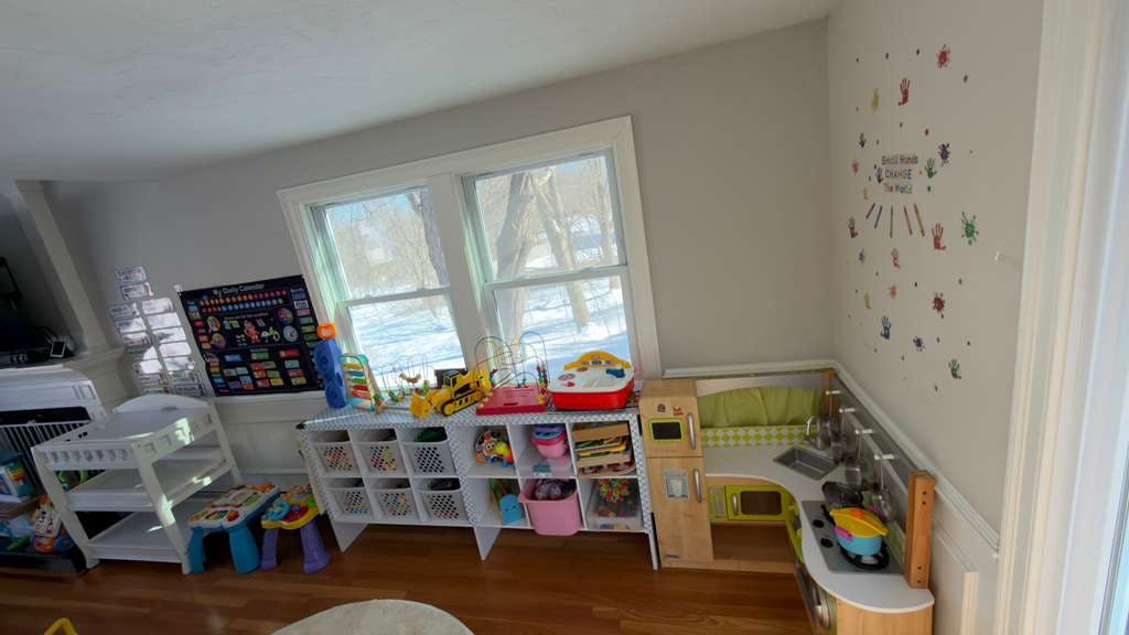 Children's playroom with toys, a changing table, and a play kitchen