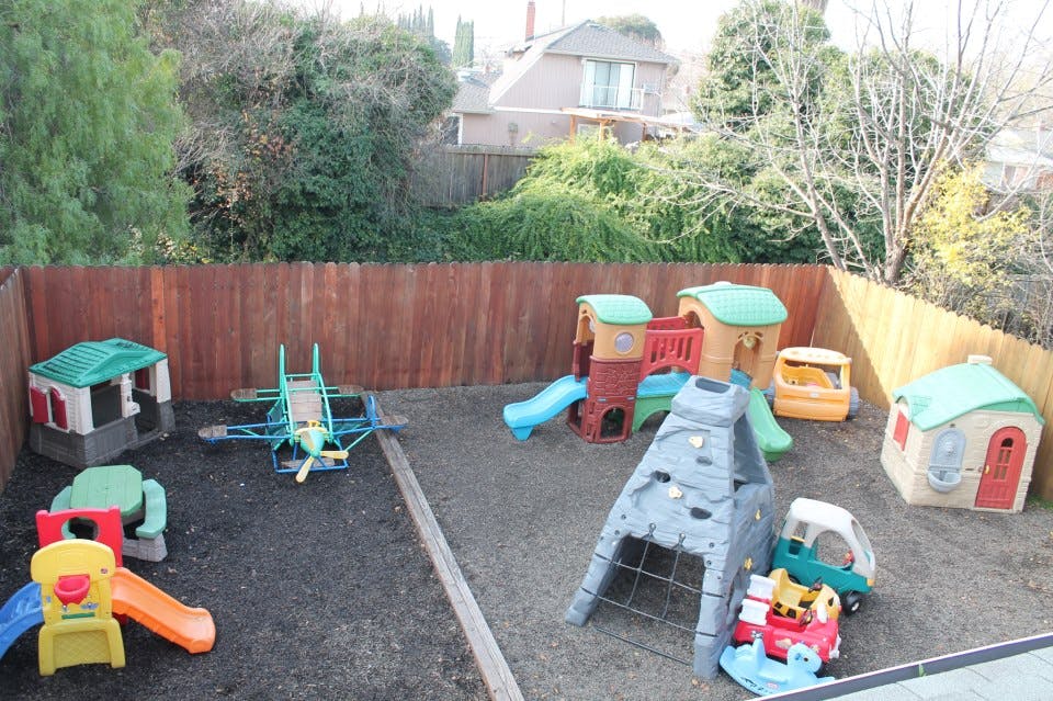 Outdoor play area with various plastic playhouses and slides