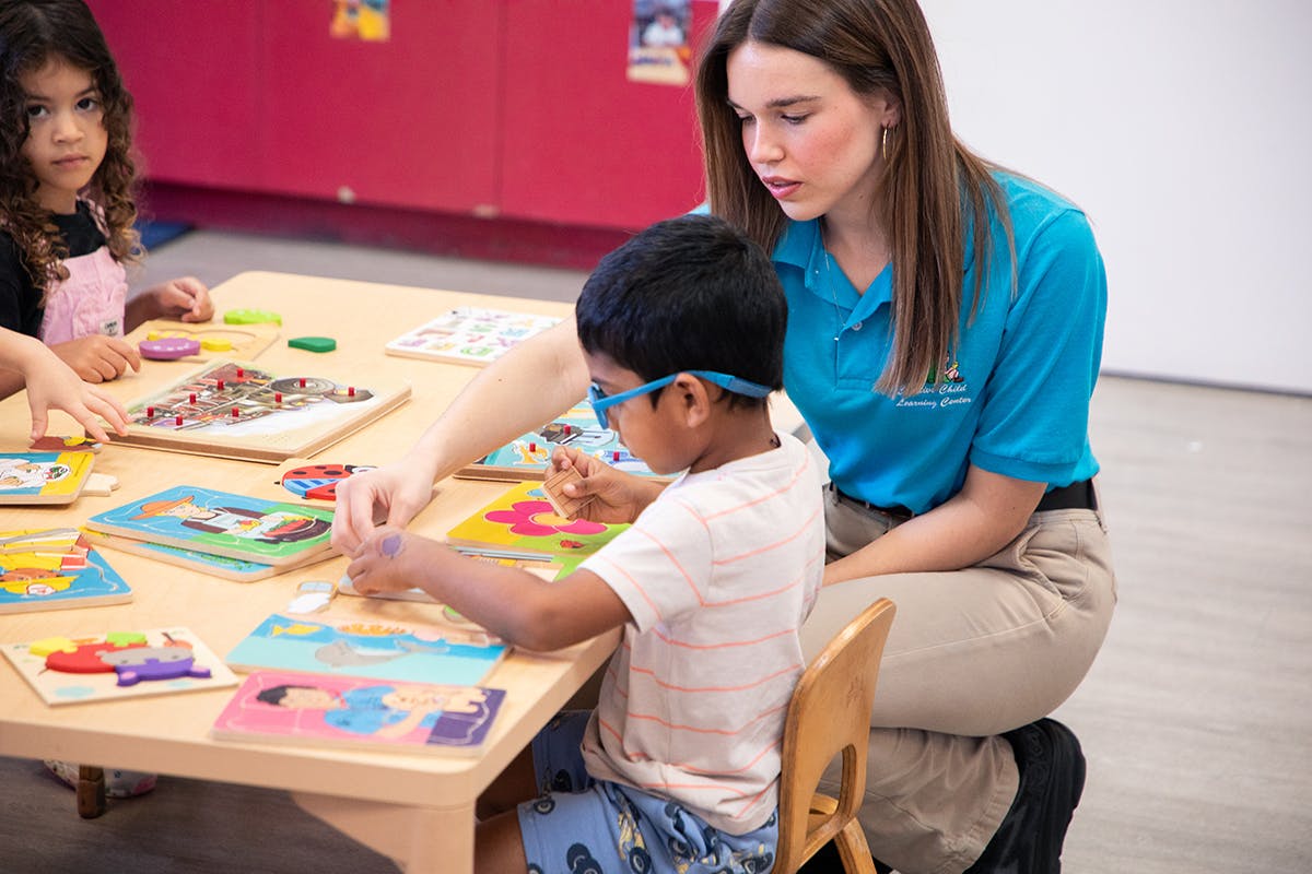 Adult and children doing puzzles at a table