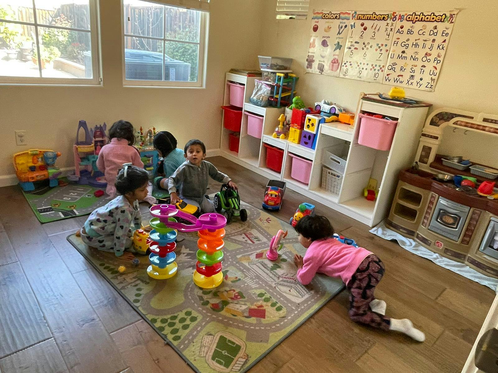 Children playing with toys on a rug in a room