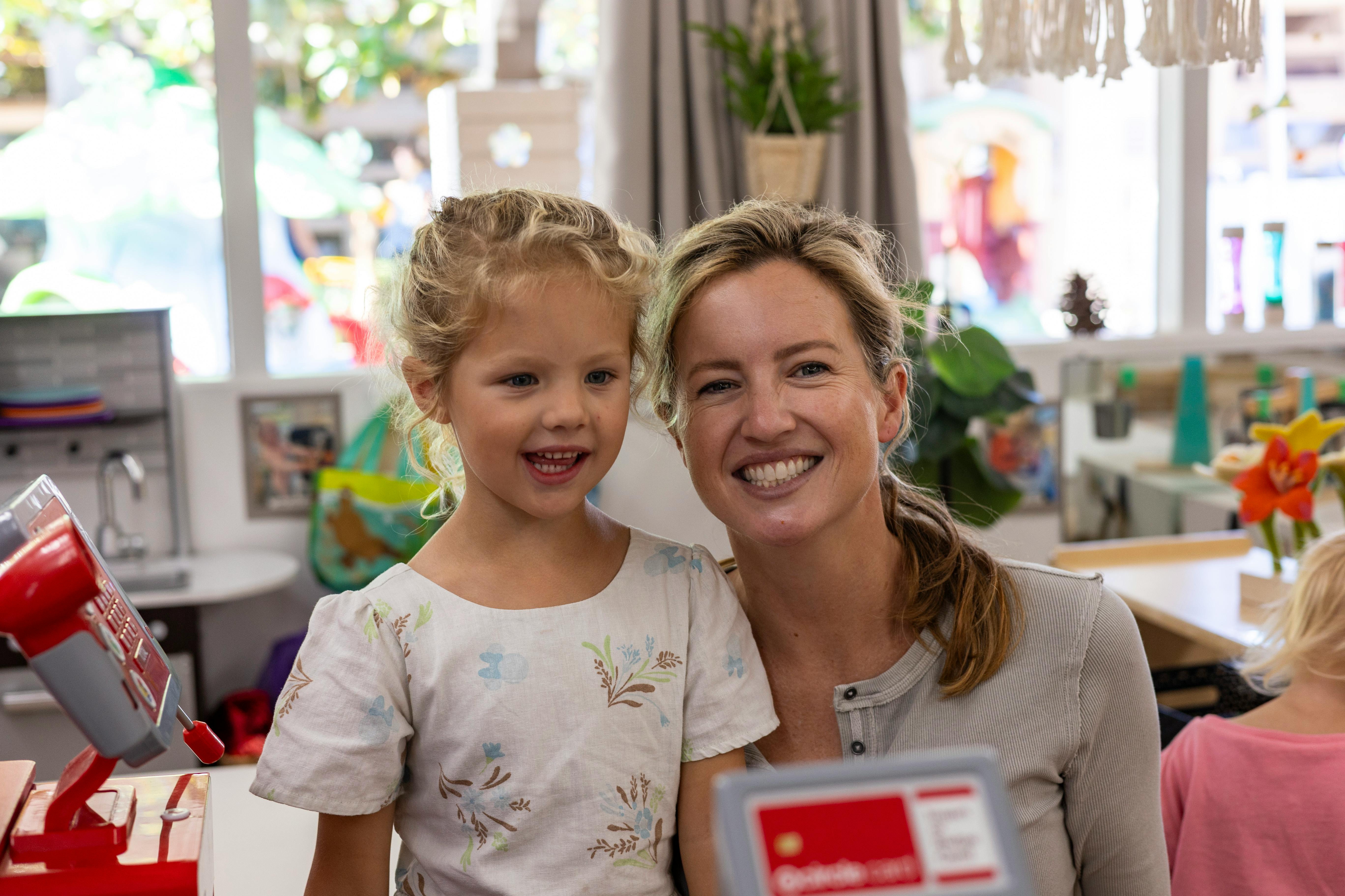 Adult and child smiling in a classroom