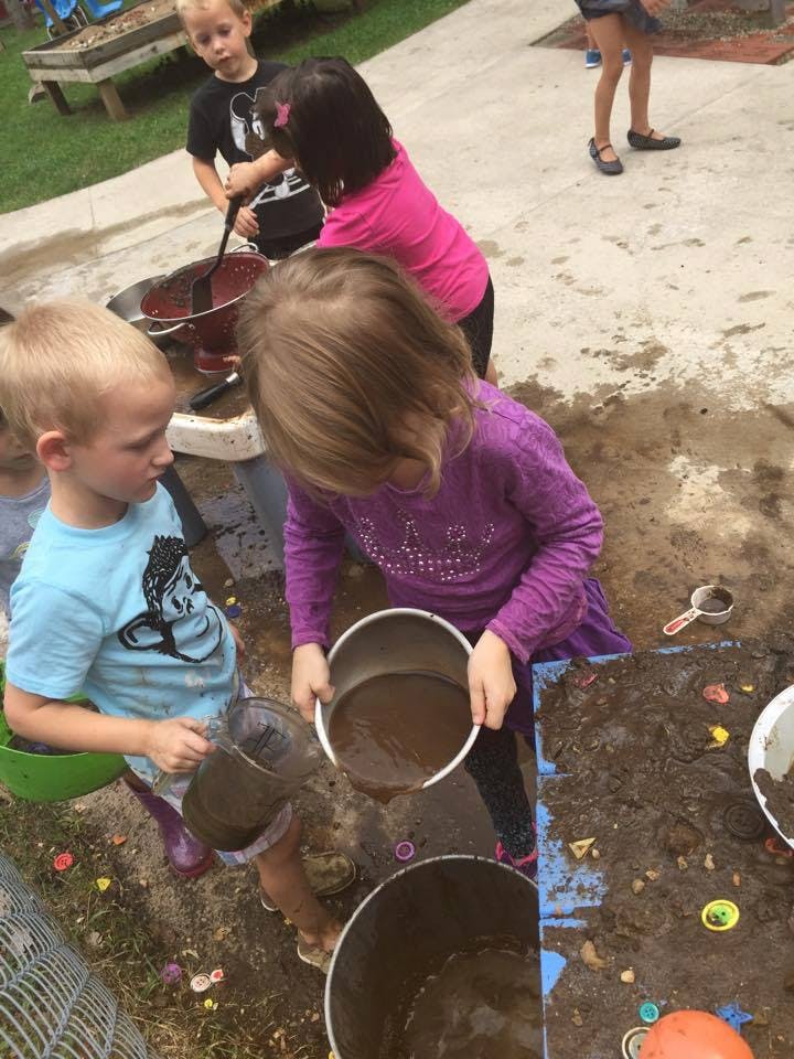 Children playing with mud and water in buckets