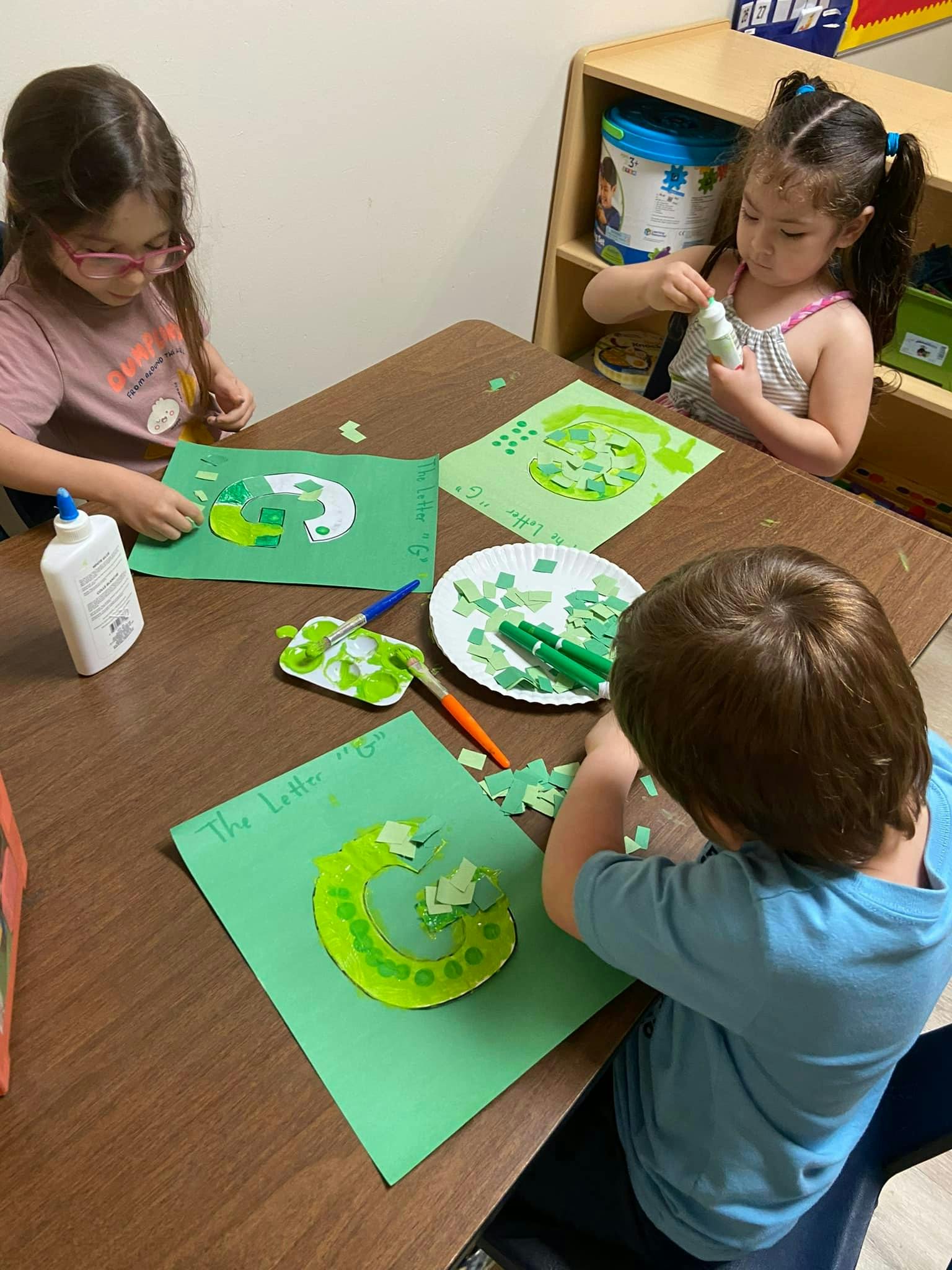 Three children doing crafts at a table