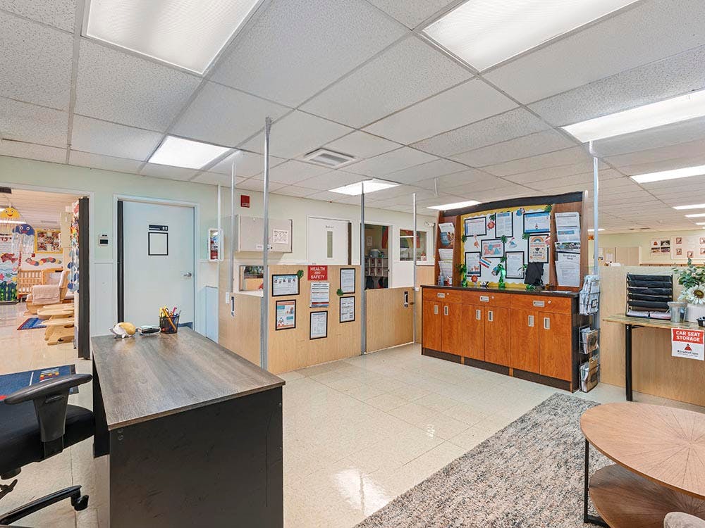 Reception area in a school with a desk, chair, and bulletin board
