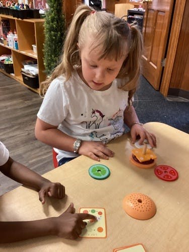 Child playing with toy food at a table