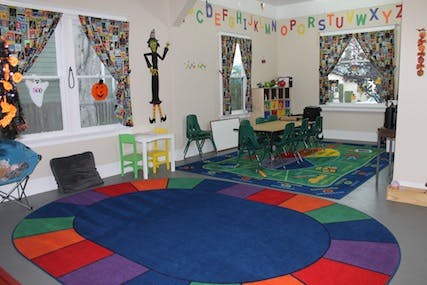 Classroom with colorful rugs, small tables, and chairs