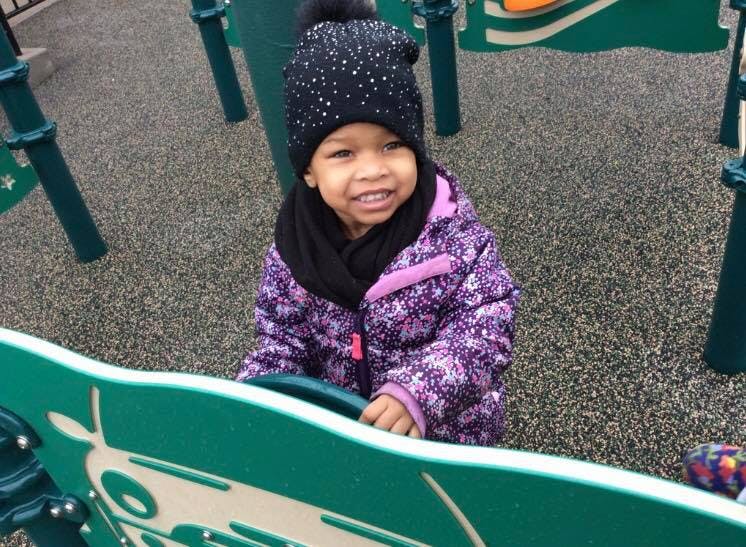Child in a winter hat and jacket on a playground