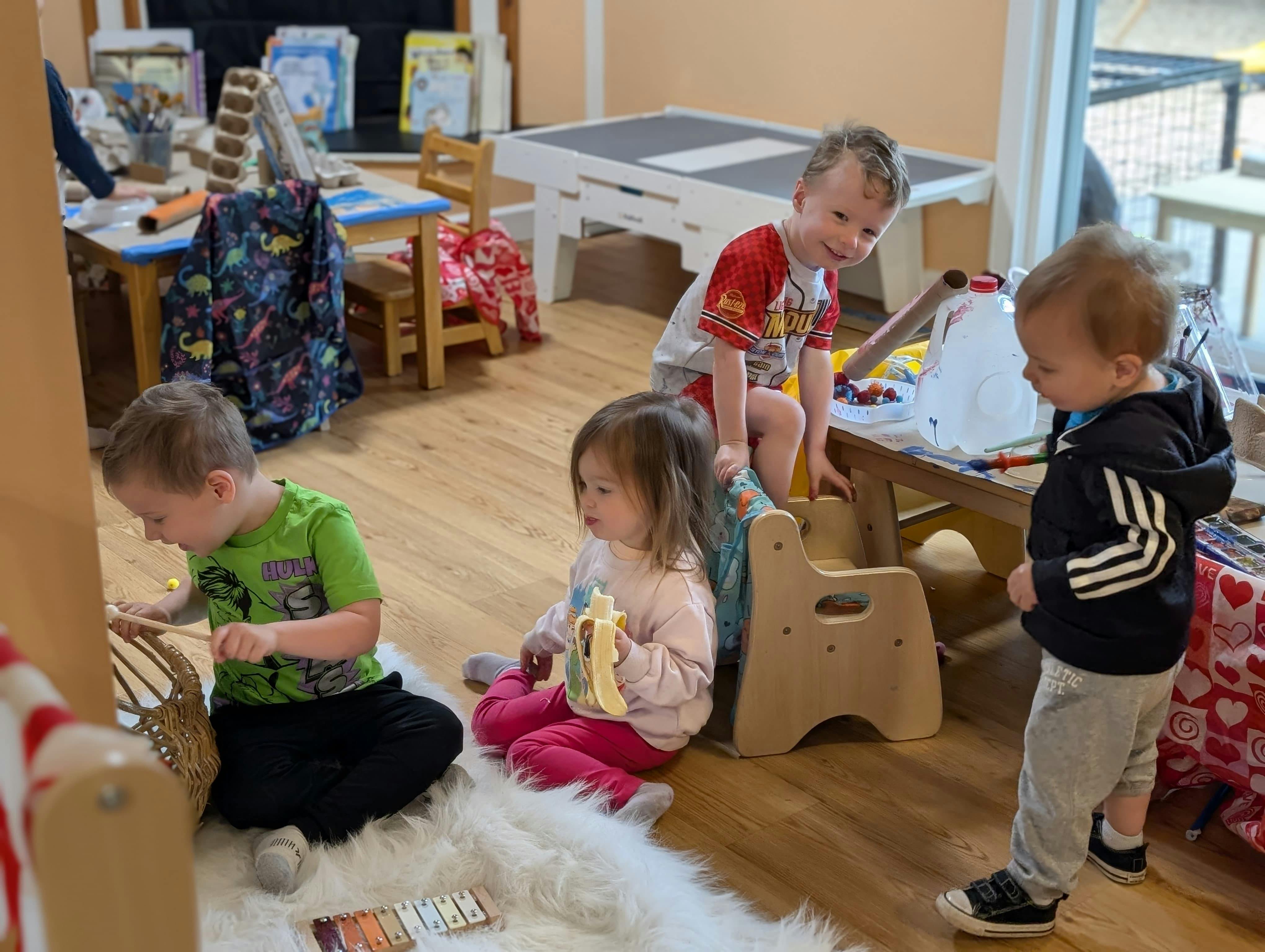 Three children playing and eating in a classroom