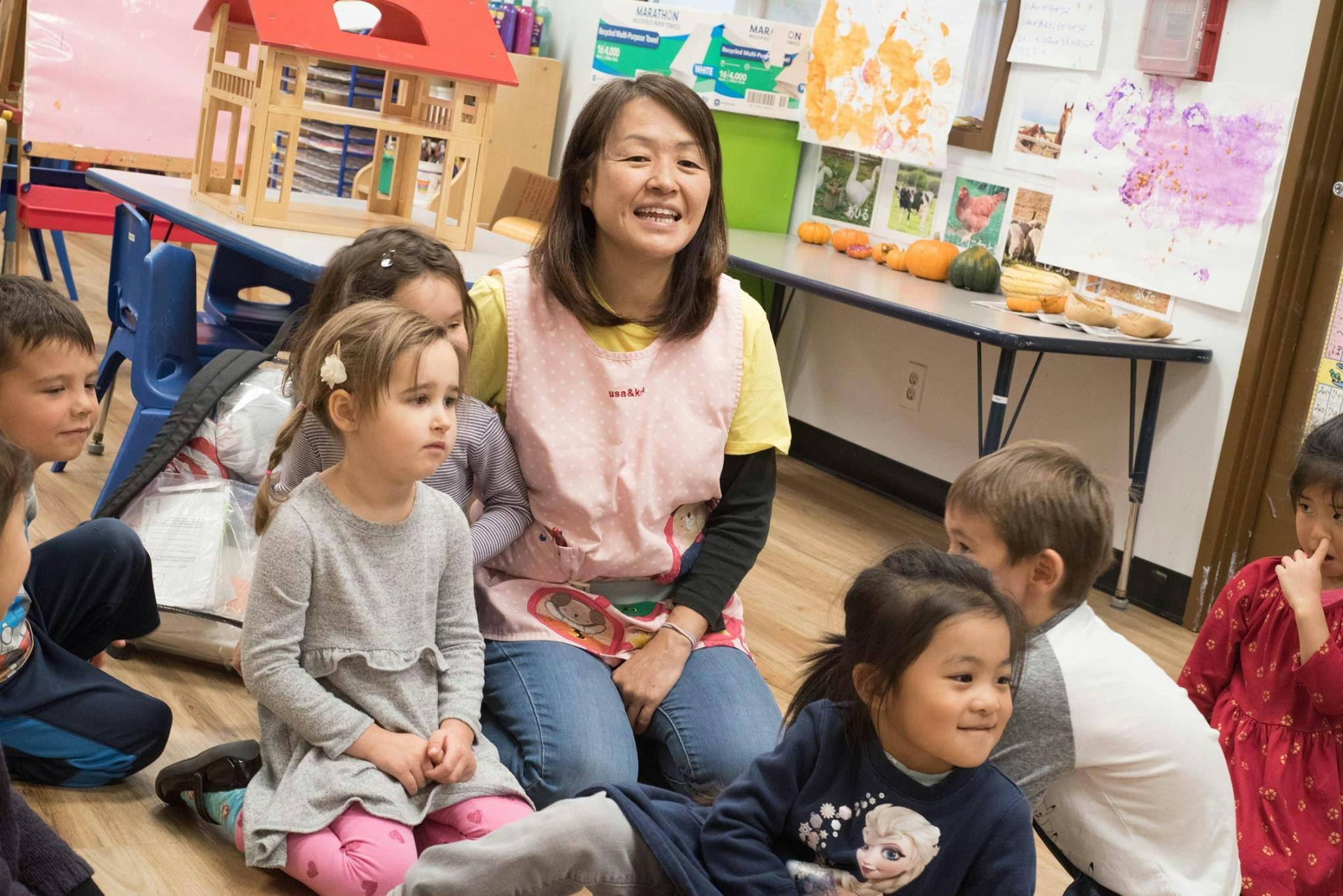 Adult and children sitting on the floor in a classroom