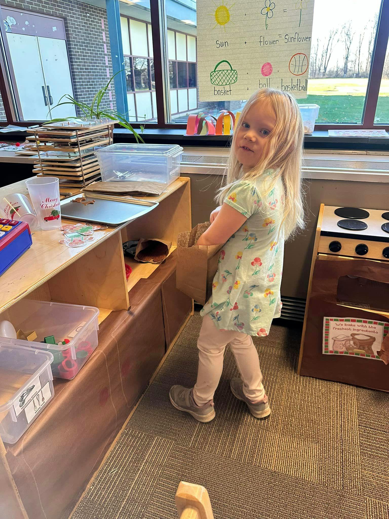 Child standing in a classroom looking over shoulder