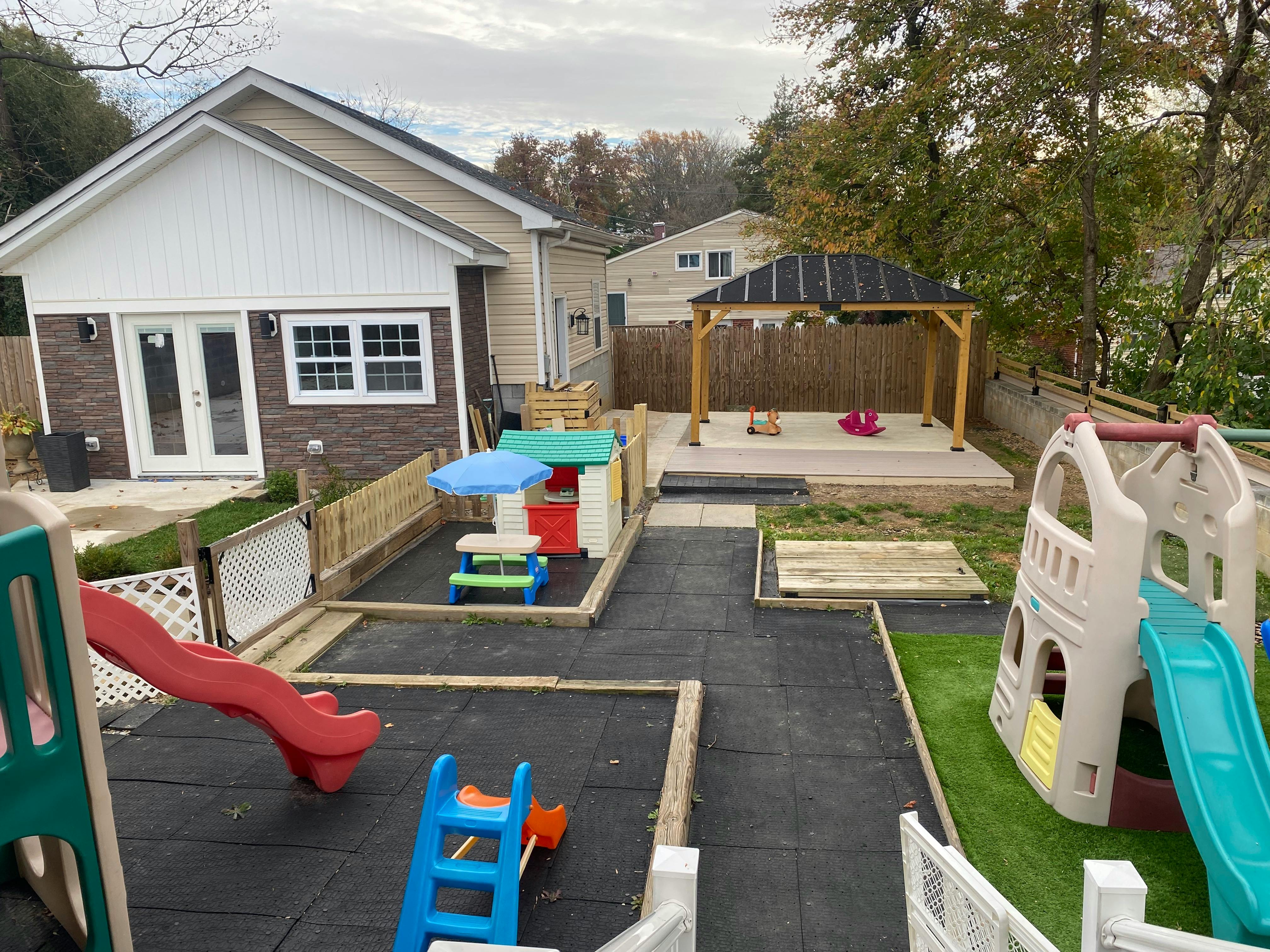 Outdoor playground with slides, playhouses, and a covered sandbox