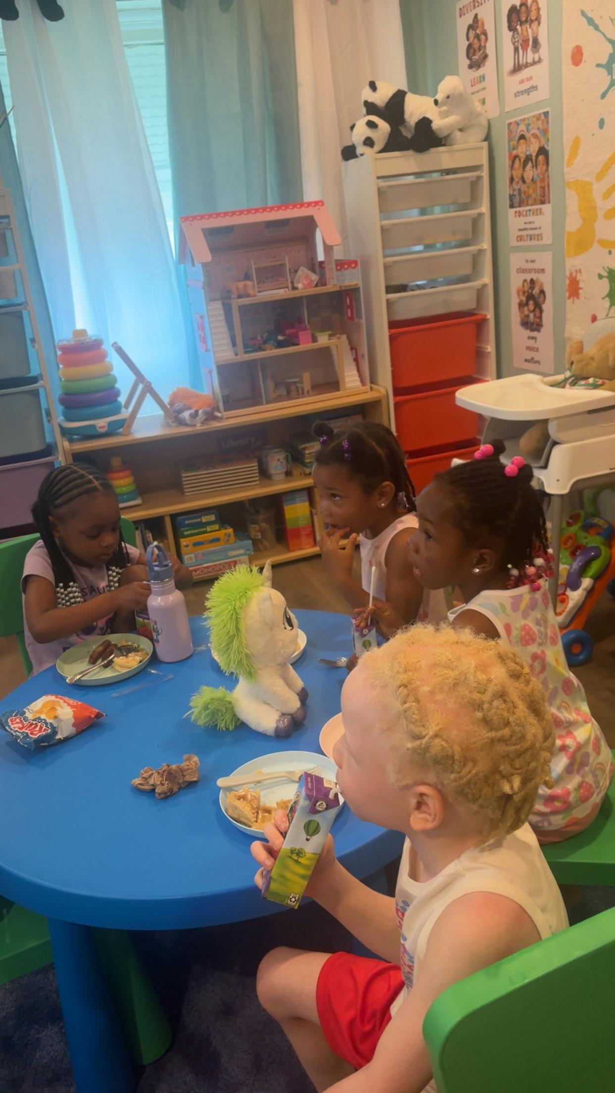 Children eating at a blue table in a classroom