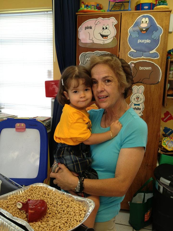Person holding a child in a classroom