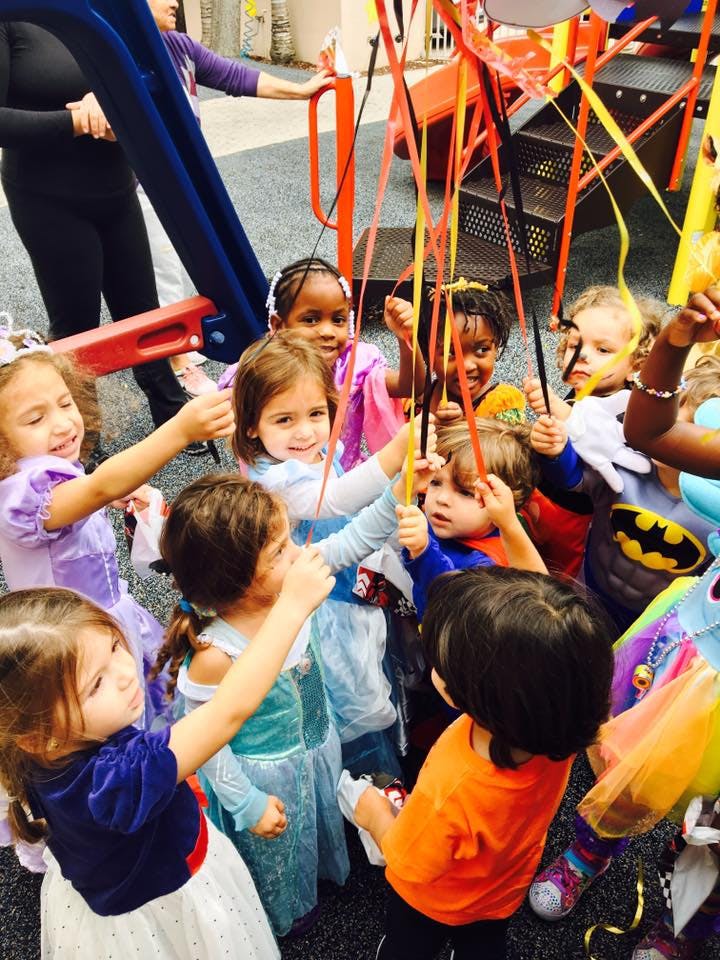 Children holding colorful ribbons on a playground