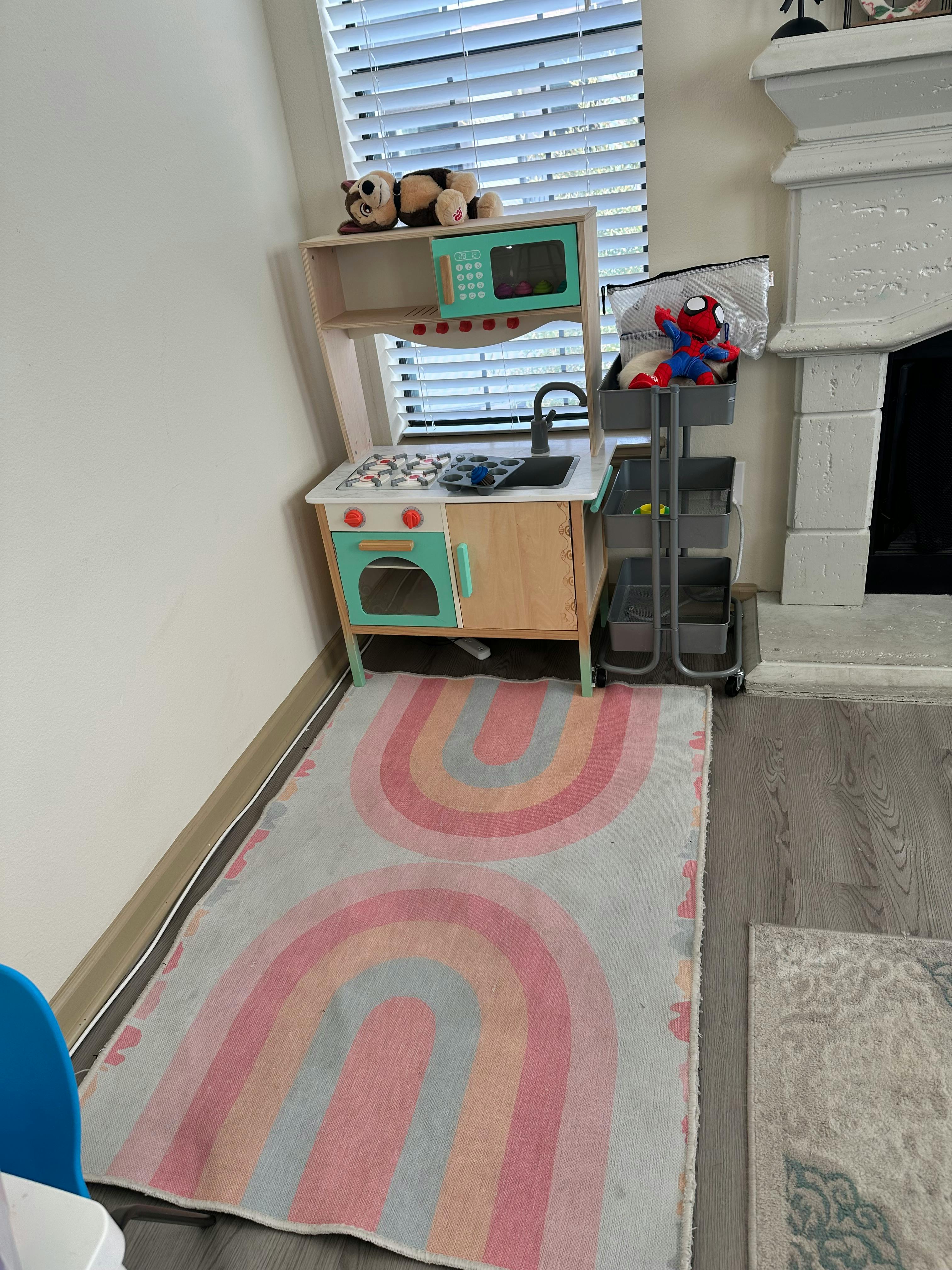 Child's play kitchen with a rainbow rug
