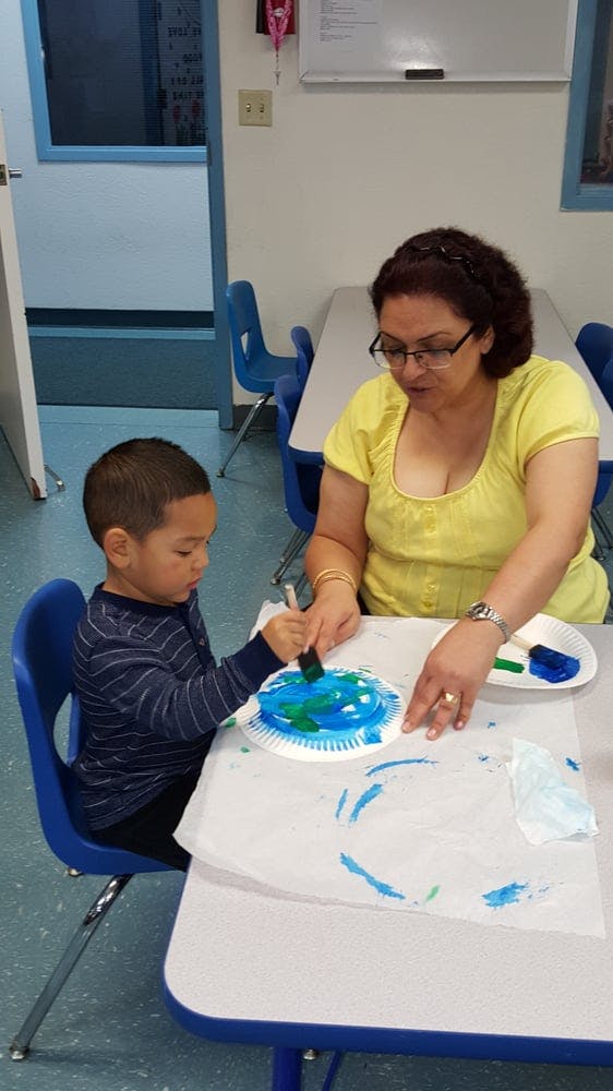 Adult and child painting together at a table