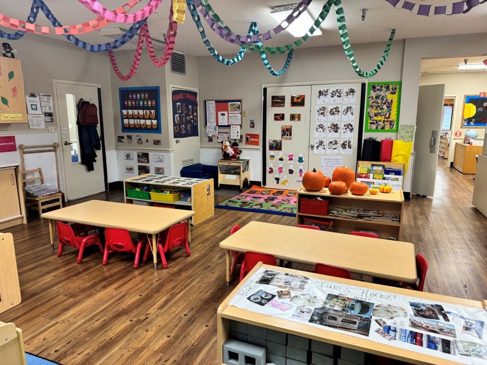Classroom with small tables and chairs, paper chains, and pumpkins