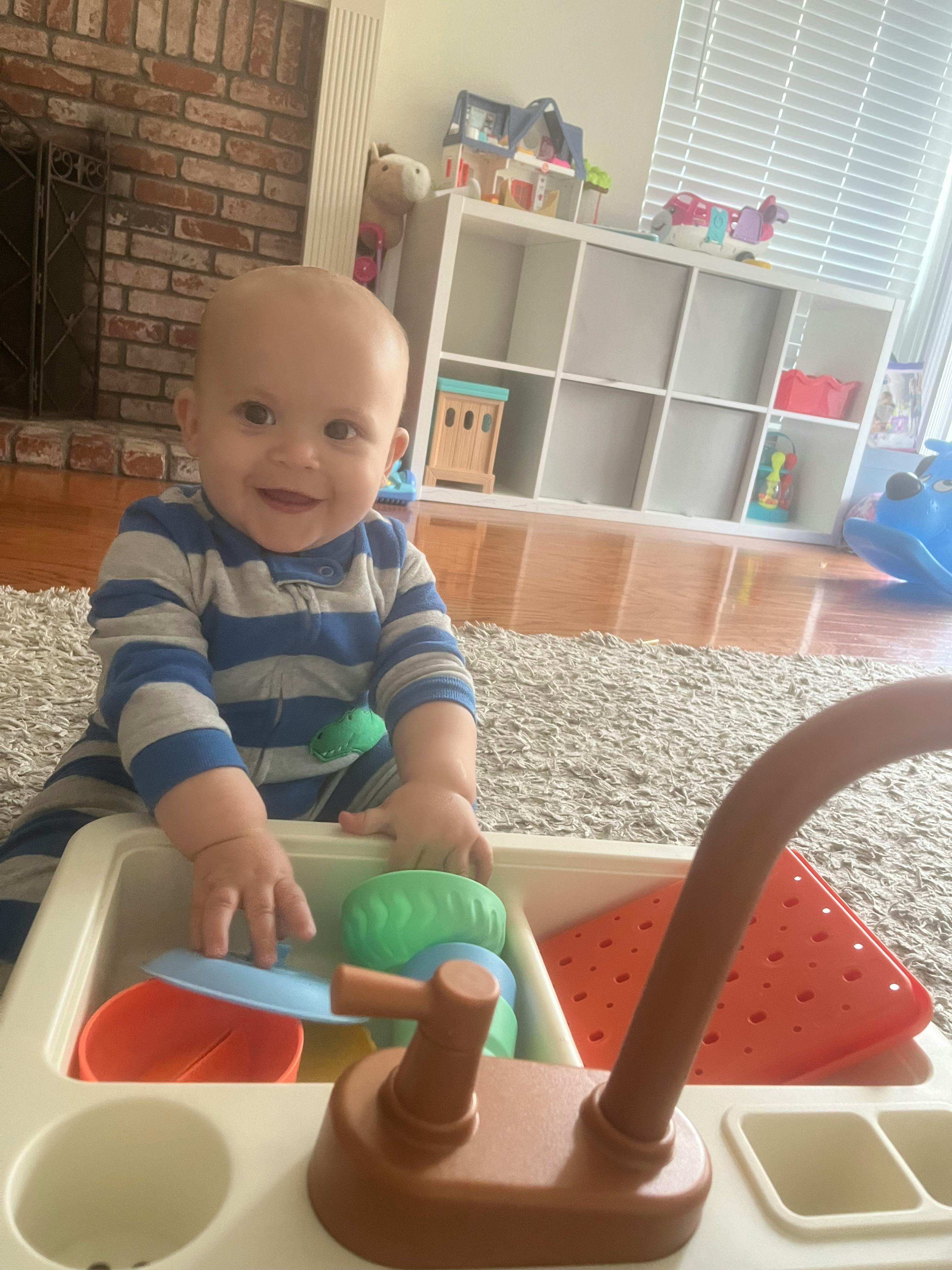 Child playing with a toy kitchen sink