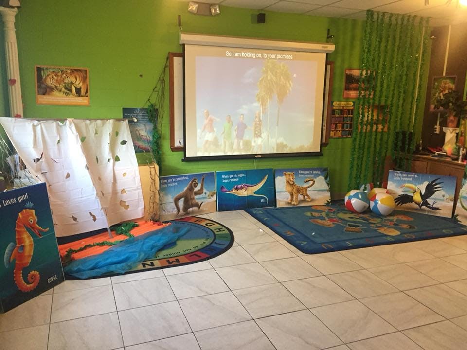 Classroom with projector screen, rugs, and large books
