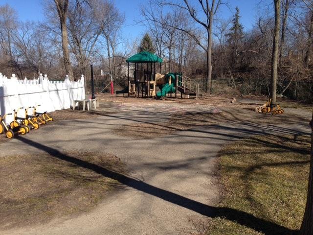 Children's playground with playset and small yellow tricycles