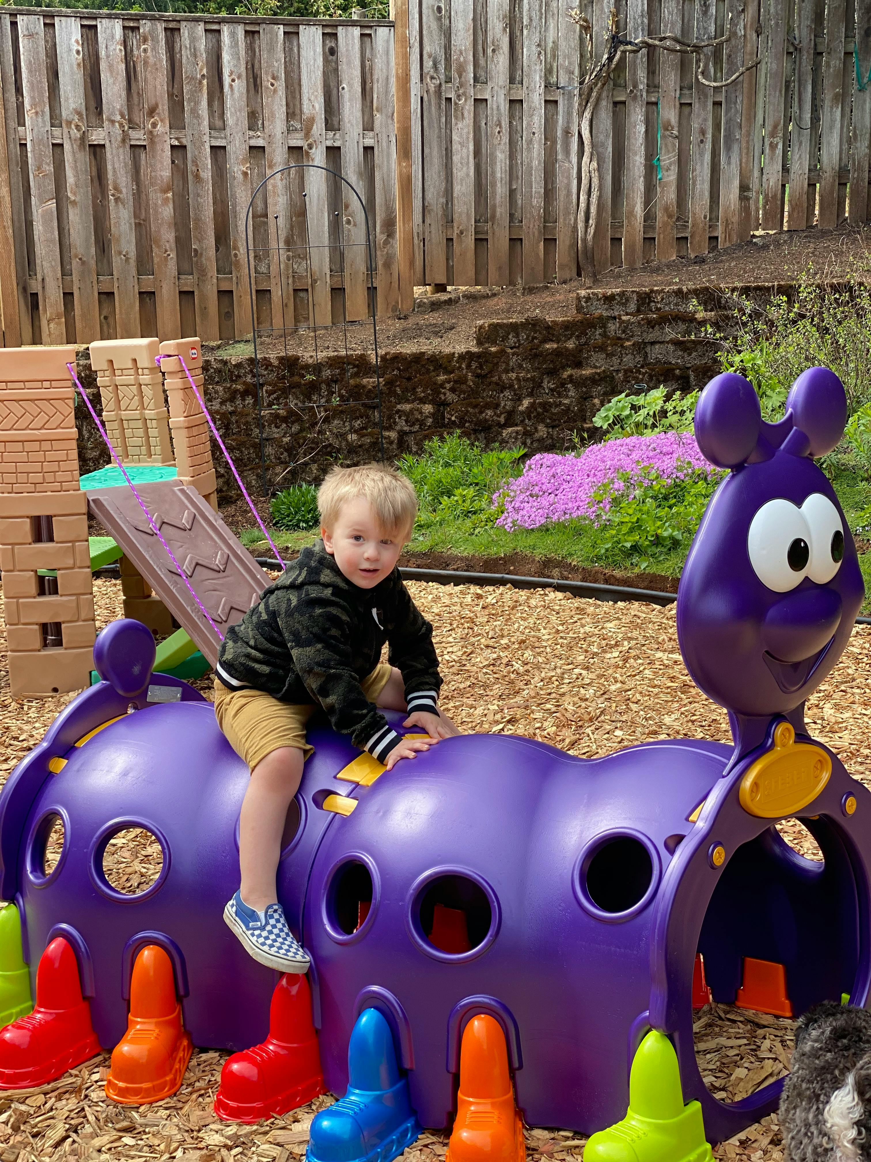 Child on a purple caterpillar playground climber