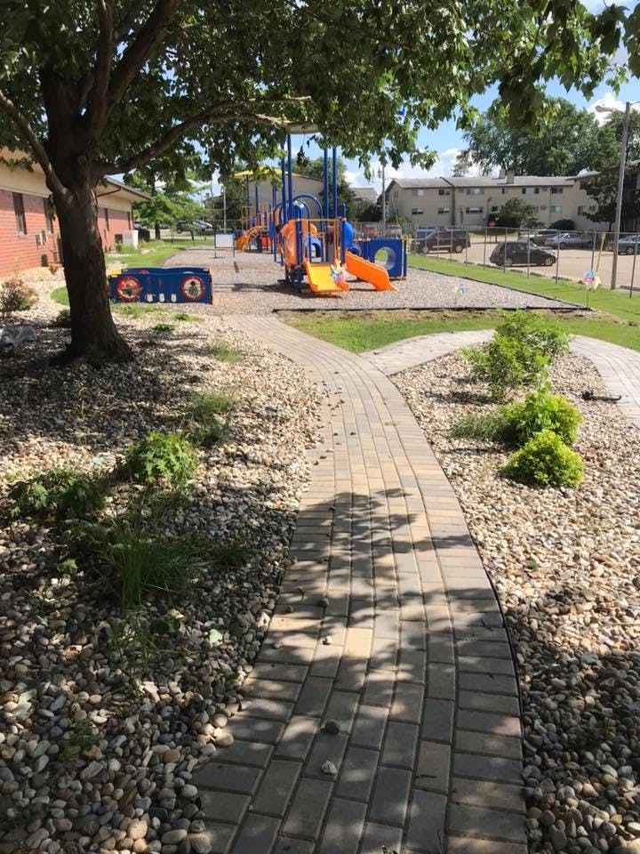 Playground with slides and climbing structures next to a paved path