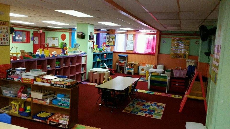 Classroom with shelves of books and toys, tables, and chairs