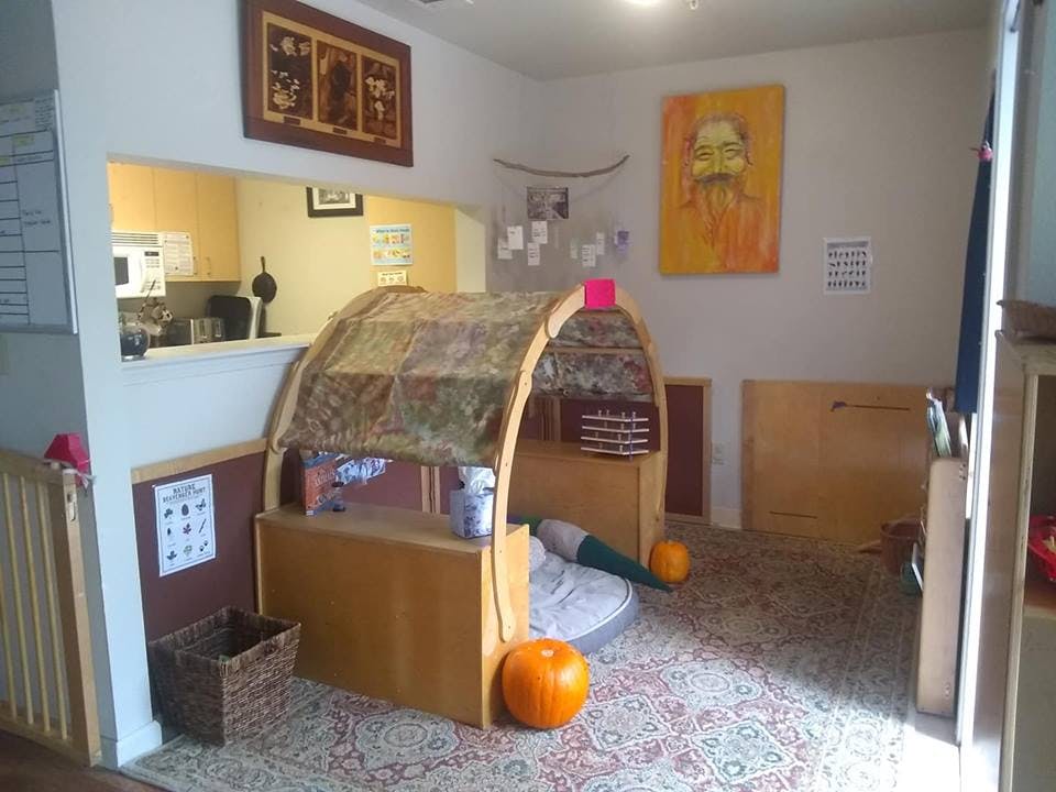 Play area with wooden arch structure and kitchen in background