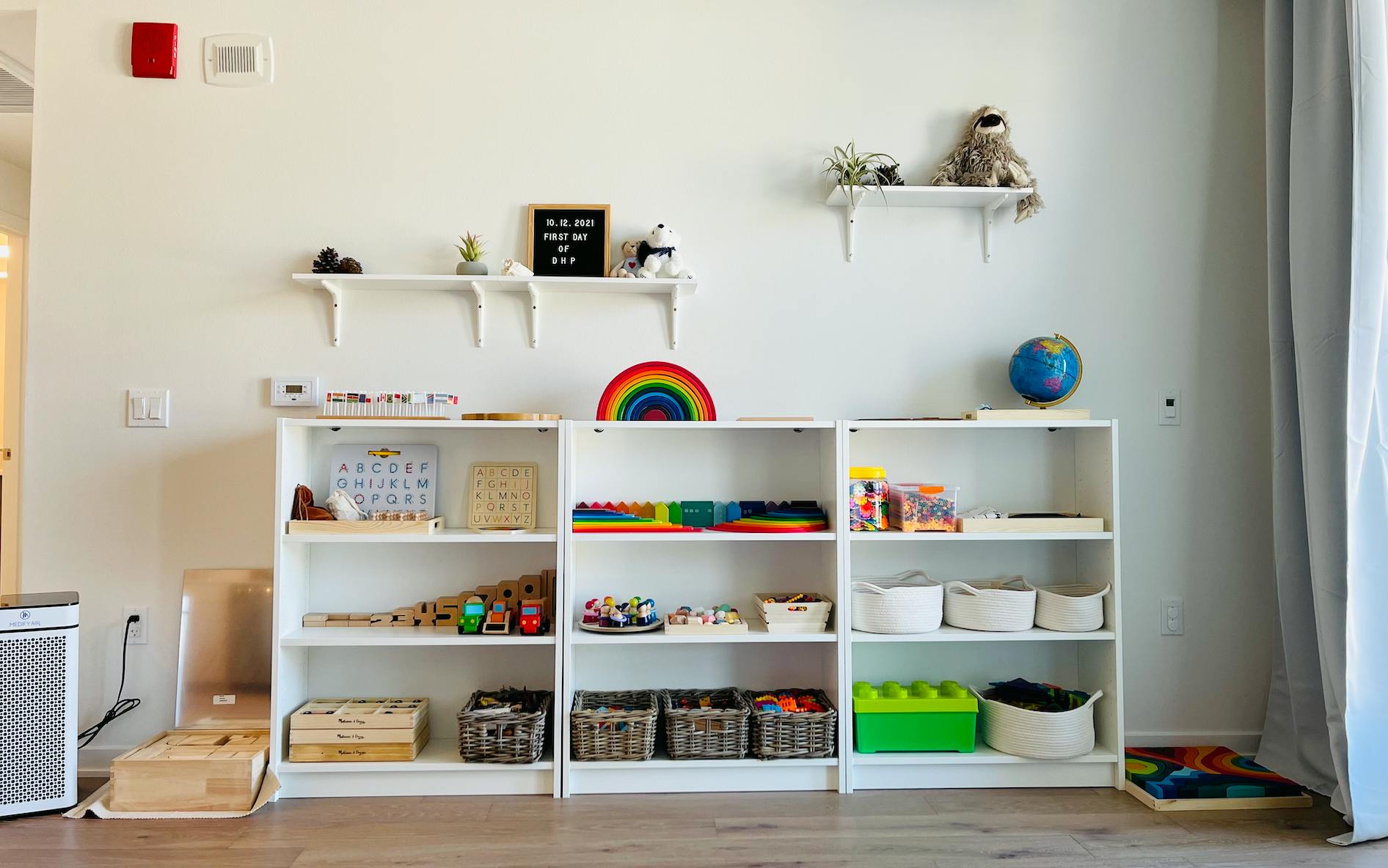 White shelves with toys and learning materials in a room