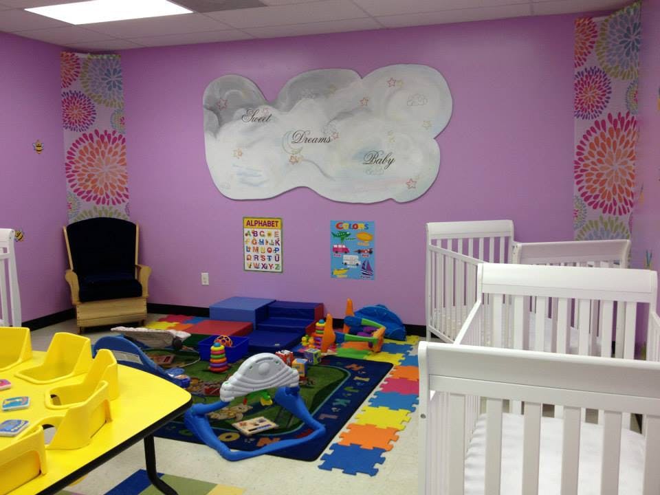 Nursery room with cribs, play mat, and toys